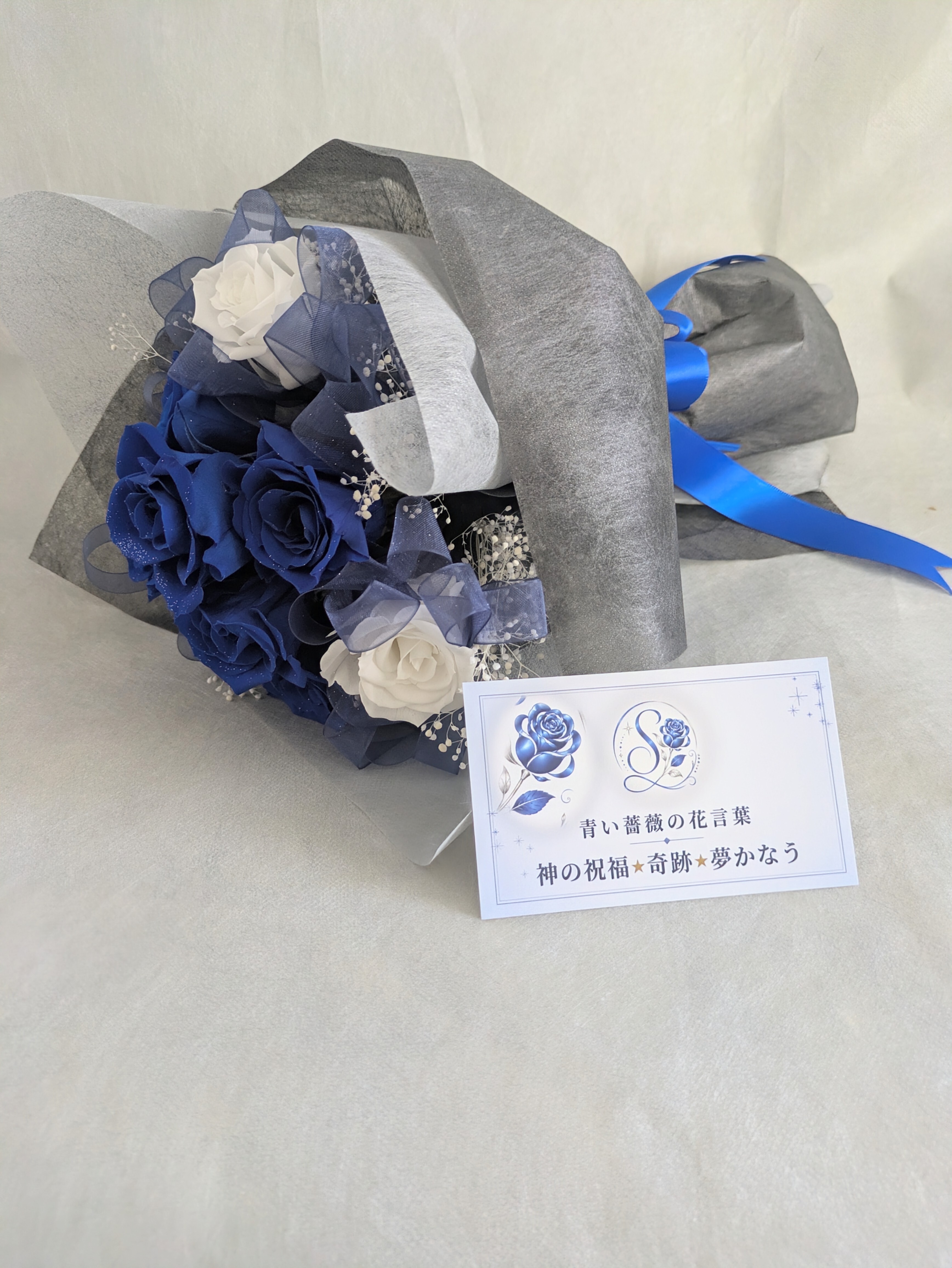 プリザーブドフラワー／青い薔薇と白い薔薇輪のふんわりかすみ草の花束（黒グレー花束ラッピング）